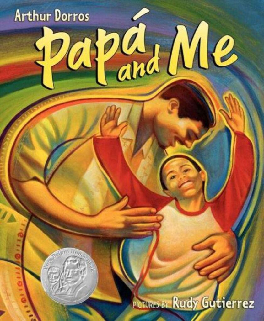 Cover of Papa and Me. Father and son, with father with his arm around his son. There are swirled colors behind the people.